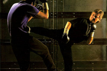 Chris Kent demonstrating a side kick with a training partner